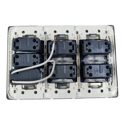 An electrical wall switch module with six black contact blocks arranged in two rows of three on a white plastic base, with two white wires connected at the top, photographed against a white background.
