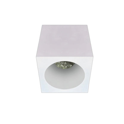 A modern square recessed light fixture with a matte white outer casing and a circular opening showing a textured, faceted clear crystal or glass top, set against a plain white background.