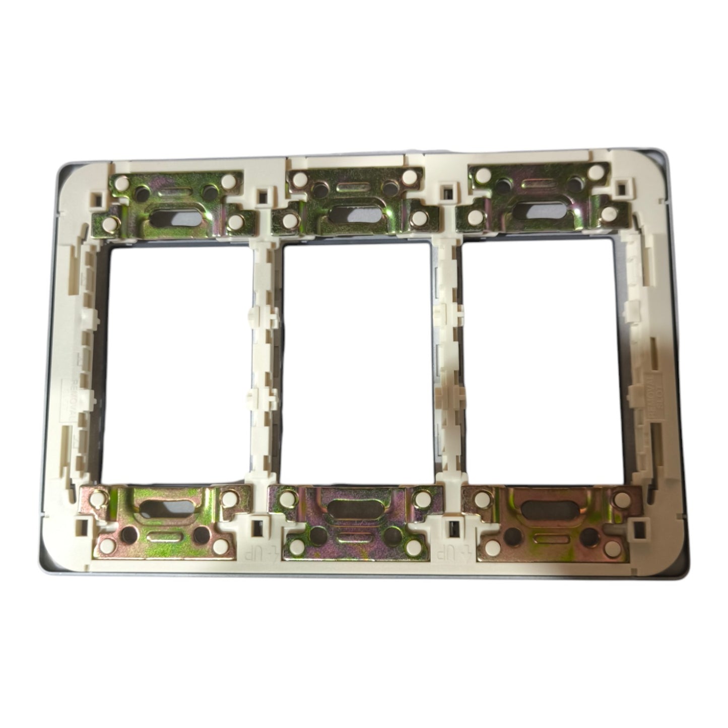 A three-gang electrical outlet plate frame with a beige plastic insert and a metallic backing showing green and gold-toned copper plating, isolated on a white background.