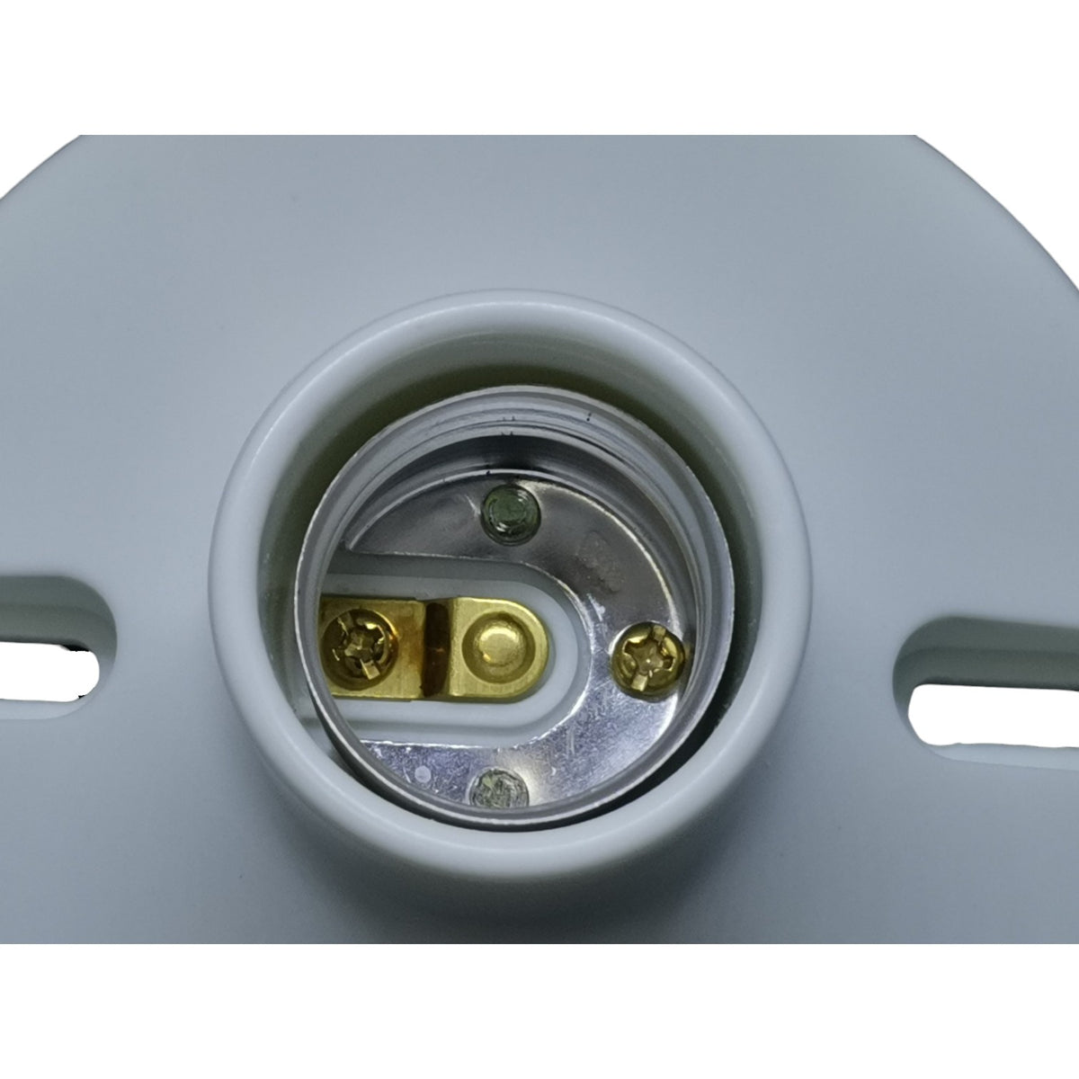 Close-up of a light socket with metallic contacts on a gray background