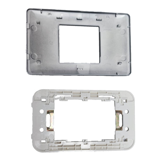 Two rectangular plastic electrical switchboard faceplate frames shown against a white background, one metallic silver and one light gray with gold terminal screws visible.