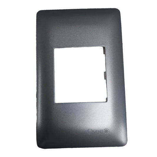 A black plastic replacement faceplate or cover with a rectangular cutout in the center, featuring a debossed 'CMNI' logo at the bottom, shown on a plain white background.