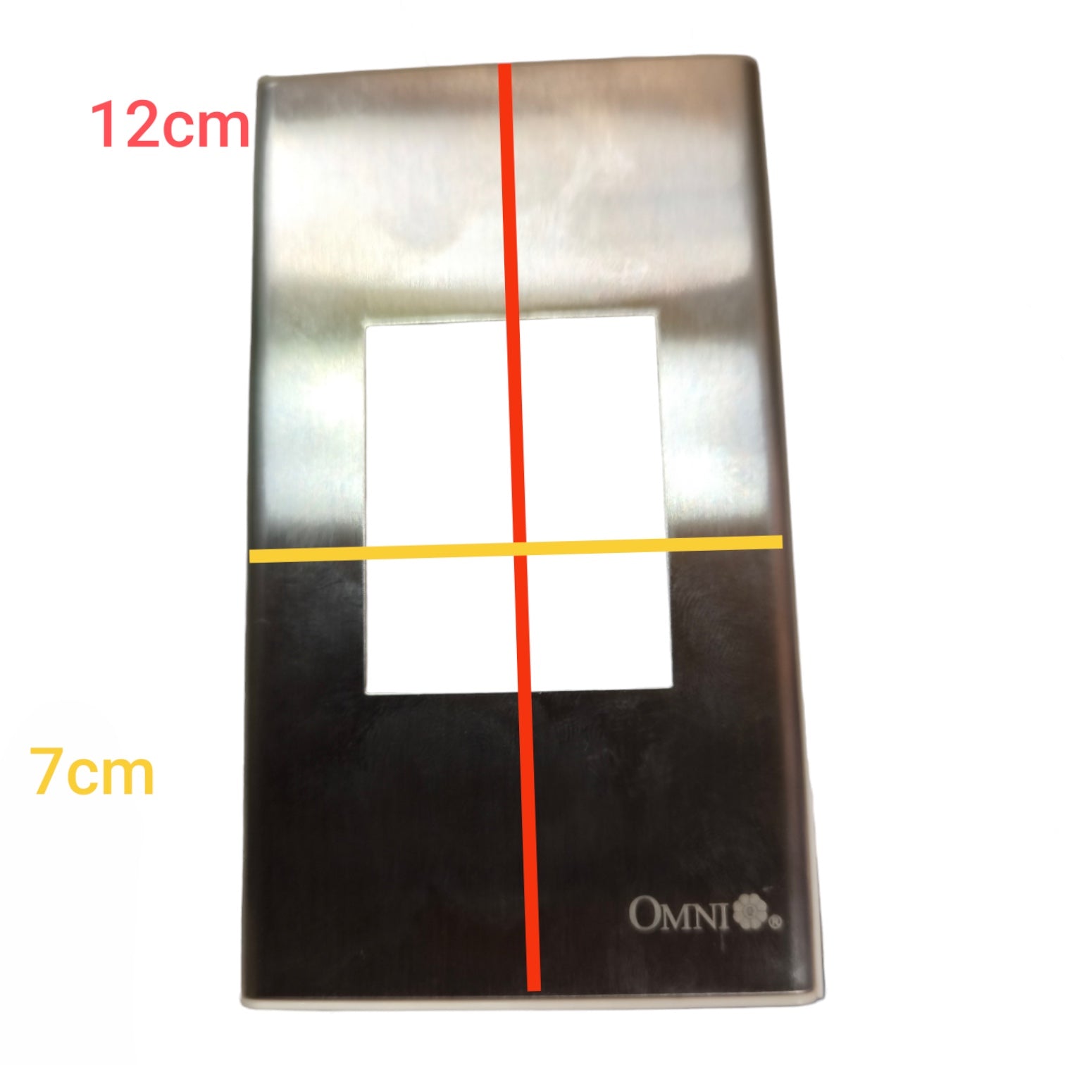 A rectangular brushed-metal wall plate or cover with a square cutout in the center, shown on a white background with red and yellow measurement lines and text indicating 12cm height and 7cm width. The brand name OMNI is visible near the bottom right.