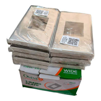 A stack of packaged Omni 1 Gang Plate wide stainless steel light switch plate covers, with the green and white retail box visible at the bottom on a plain white background.