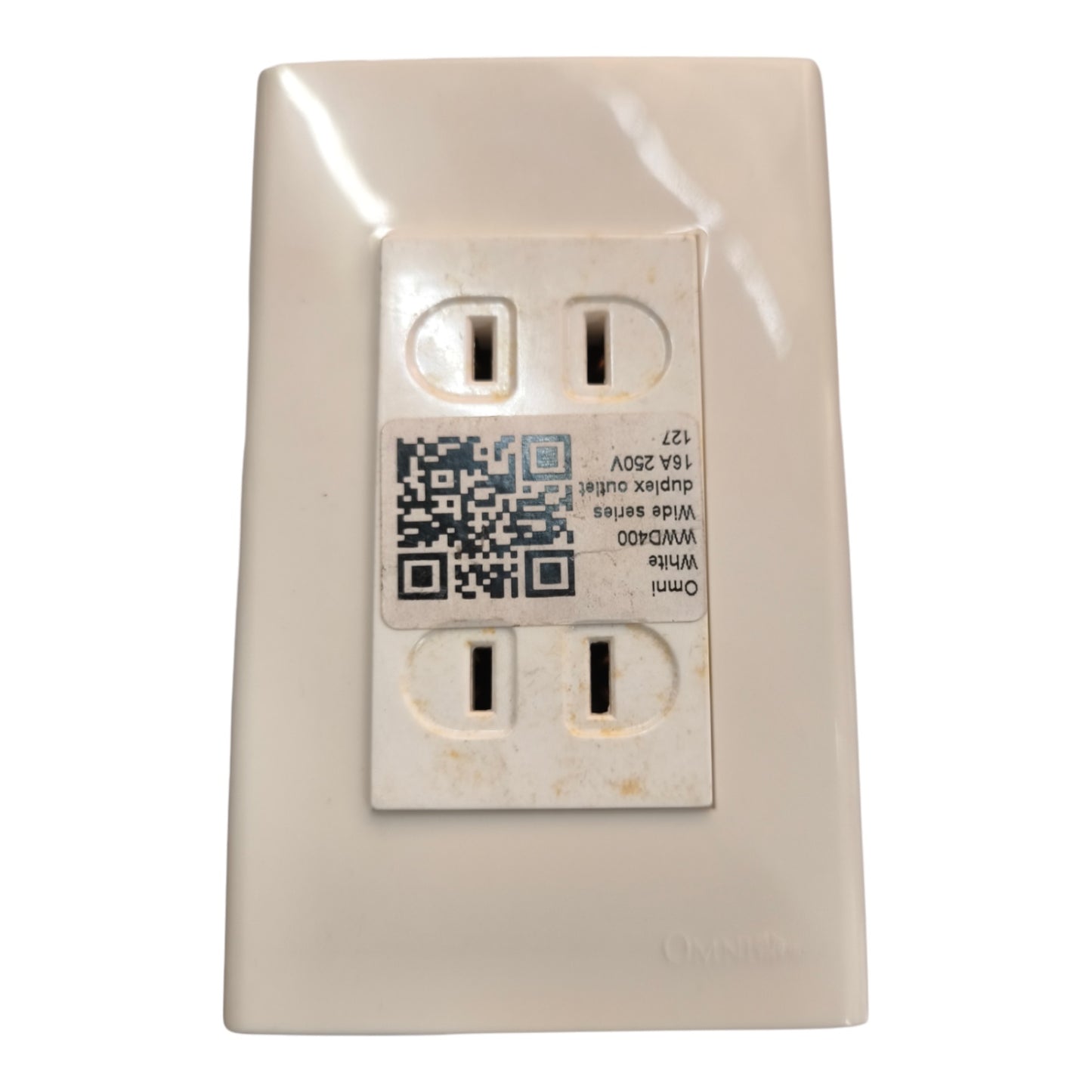 An Omnilife WVD009 dual duplex outlet cover plate in a warm off-white/cream color, featuring a central protective sticker with a QR code and product details.