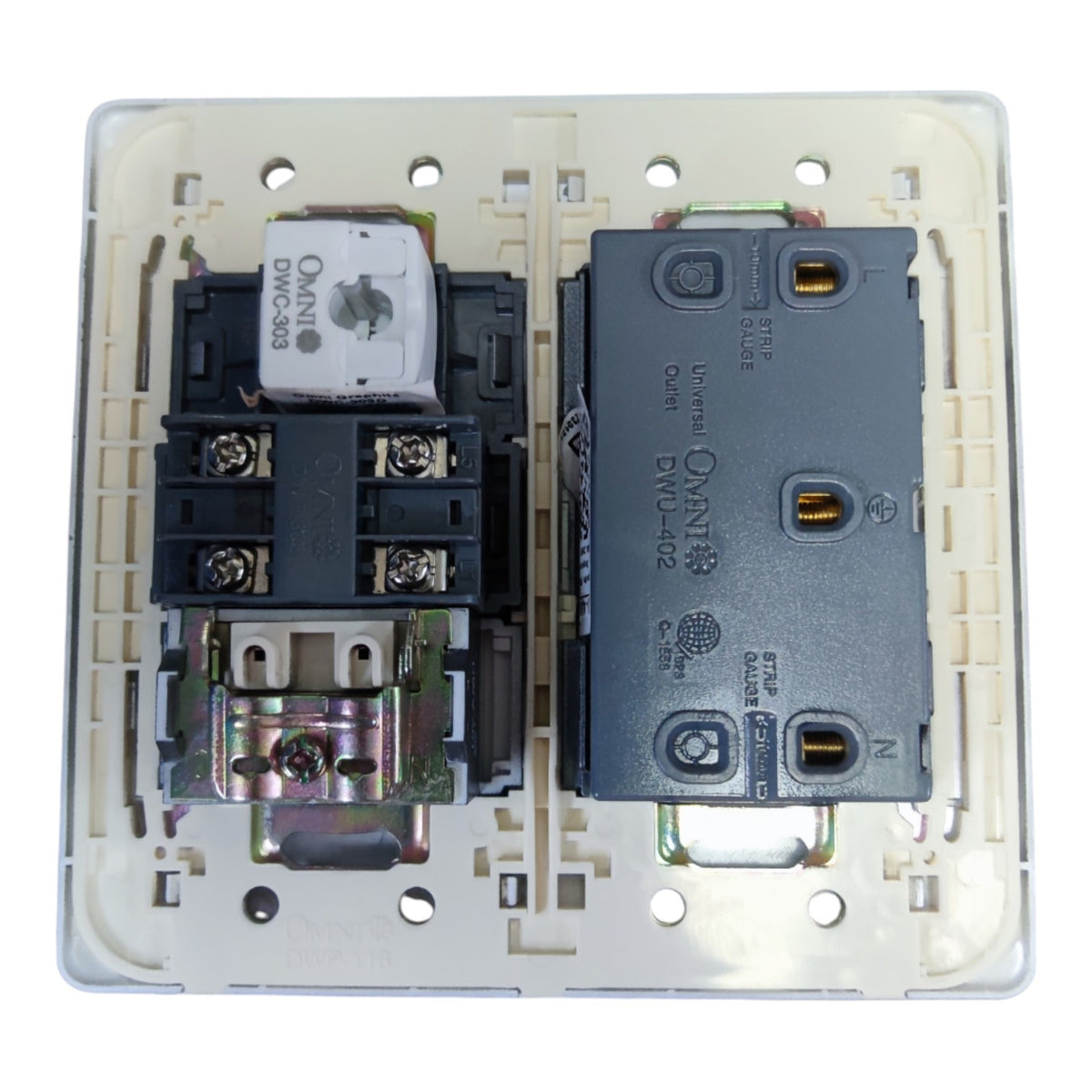 An open electrical switchboard faceplate showing two internal components: a white and black contact block on the left and a dark gray overload relay on the right, all set in a beige plastic base.