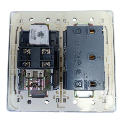 An open electrical switchboard faceplate showing two internal components: a white and black contact block on the left and a dark gray overload relay on the right, all set in a beige plastic base.