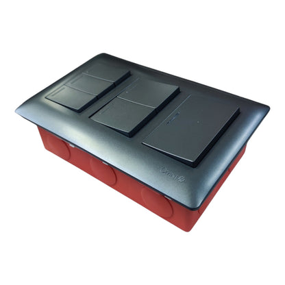 A modern three-gang double switch plate set featuring black square rocker switches on a dark gray top cover, mounted on a red junction box against a white background.