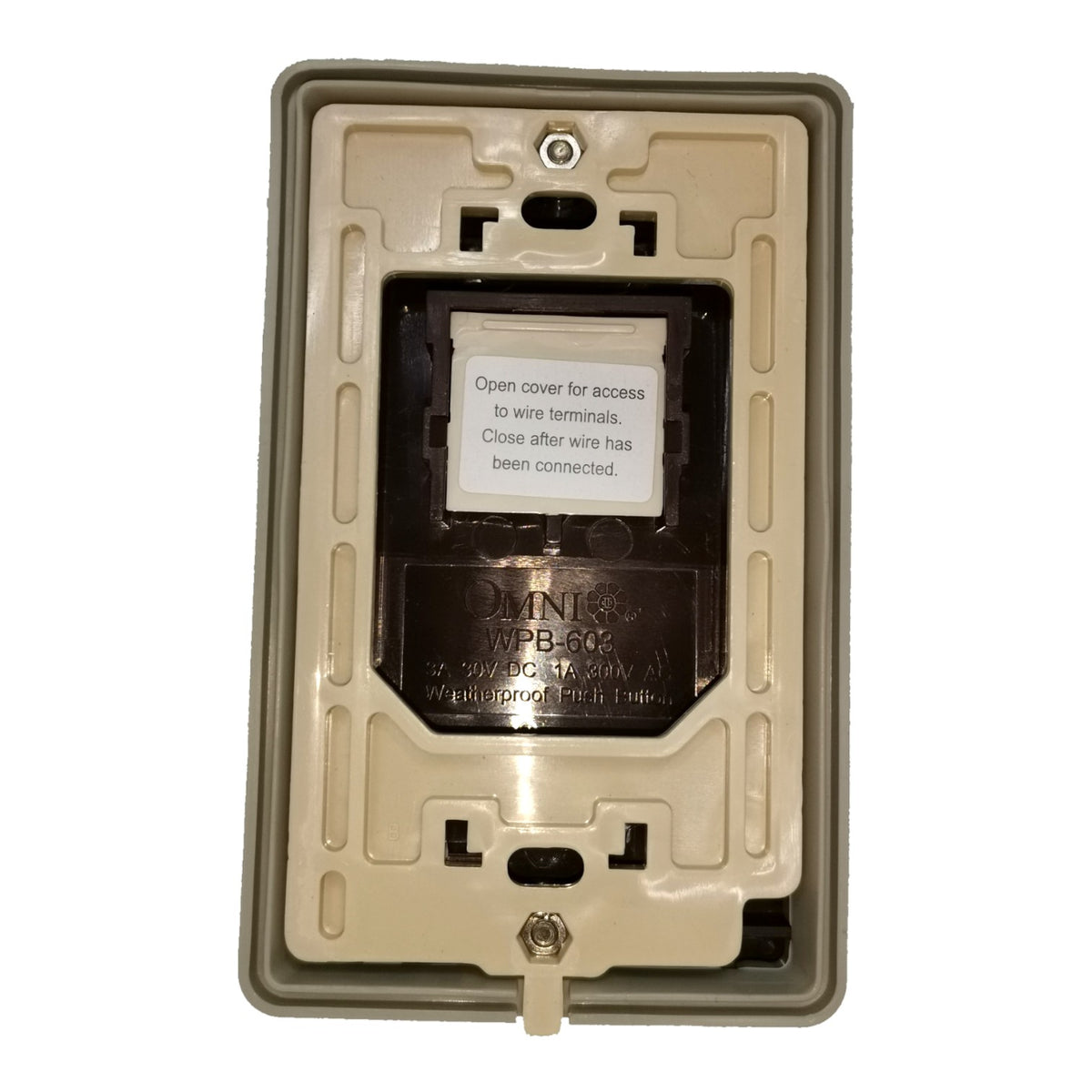 An Omnilife WPB-612 electrical outlet backplate cover in beige plastic, showing the internal terminal access cover with a white instruction label.