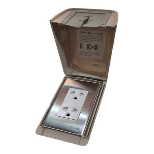 An outdoor duplex outlet cover with an open beige plastic hood showing a stainless steel outlet plate and white electrical outlet inside, photographed on a white background.