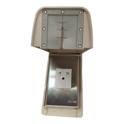 An outdoor electrical outlet cover with a beige plastic housing, a stainless steel outlet plate, and a matching metal top cover with a vented cross-slot design.