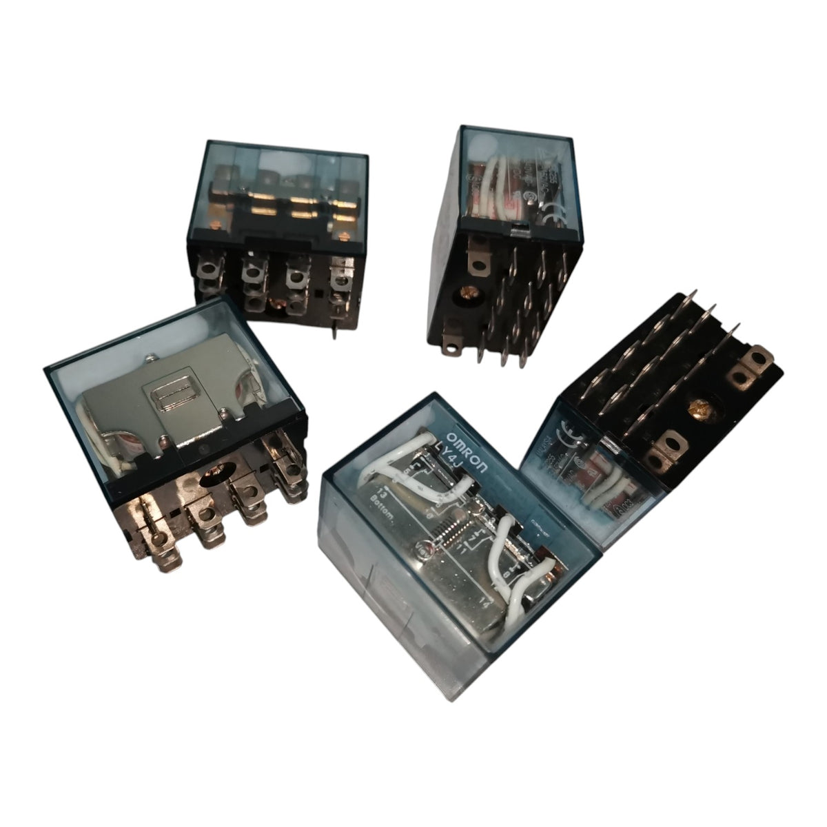 Four industrial electrical relays with transparent housings, showing internal wiring and metal terminals, arranged on a plain white background.