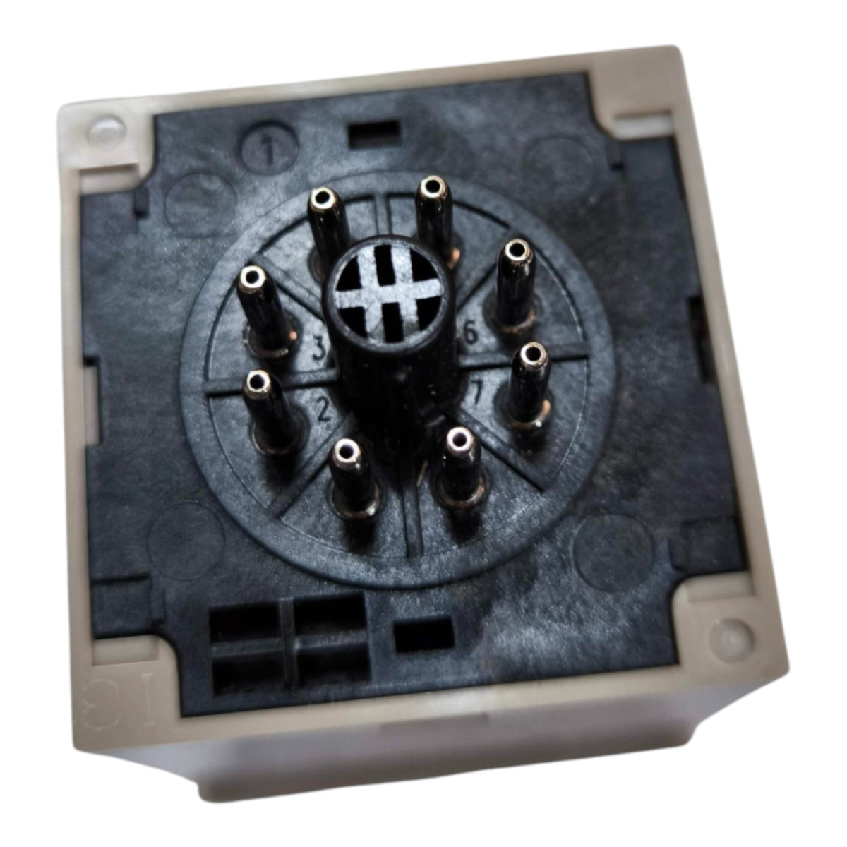 A square electrical connector or terminal block with a black circular multi-pin center and beige plastic outer housing, shown on a plain white background.