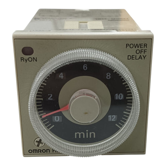 An Omron H-20 timer relay with a beige plastic housing, a clear ribbed protective cover over a black dial, and a red pointer needle.