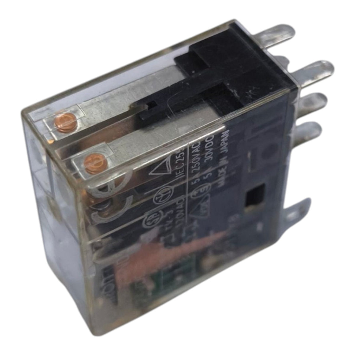 A small electrical relay with a transparent plastic housing, black internal components, copper-colored terminal screws, and silver metal pins, shown on a plain white background.