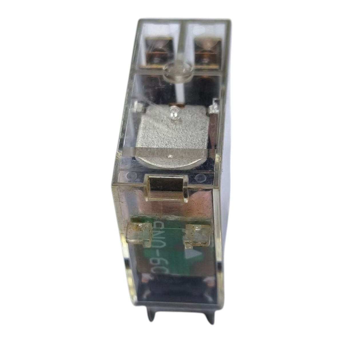 A small transparent plastic electrical relay component with internal copper-colored coils, a silver metal plunger, and green circuitry visible inside, isolated on a white background.
