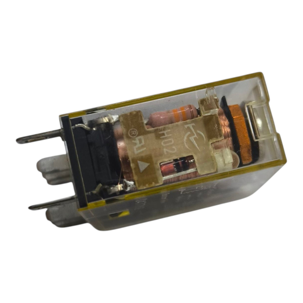 An industrial electrical relay component with a transparent plastic housing, internal copper coil, and metal terminals, shown on a plain white background.