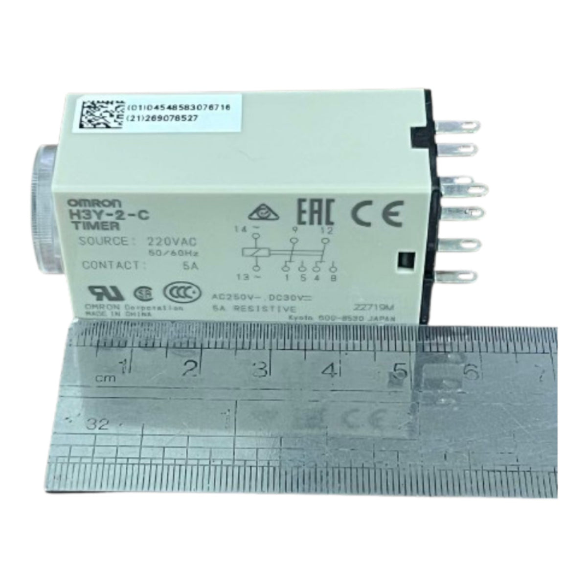 An Omron H3Y-2-C Timer electrical module shown with a metal ruler for scale, on a plain white background.