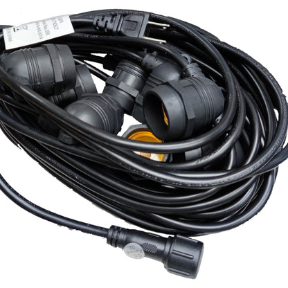 Coiled black extension cord with multiple plugs on a white background