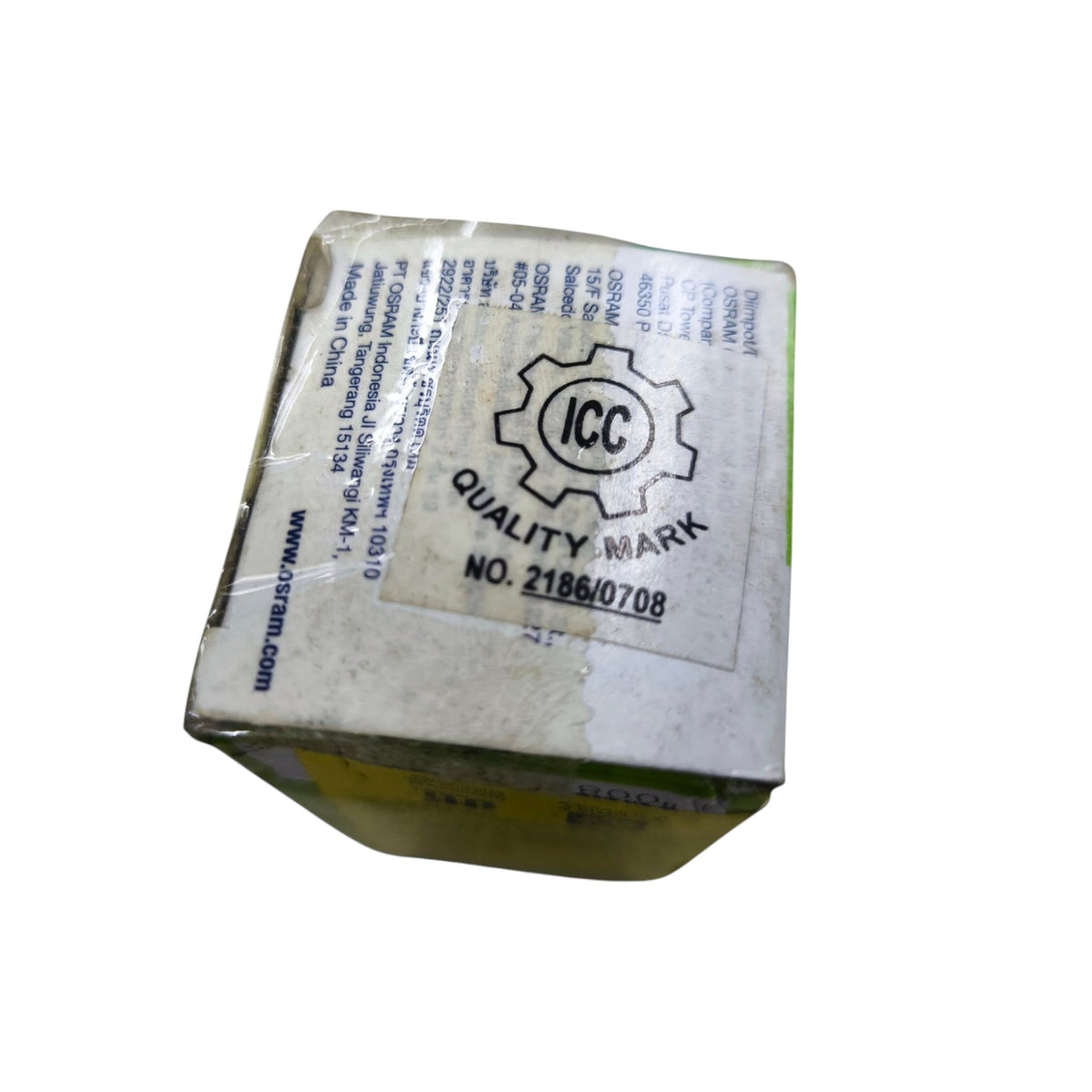 A small rectangular product box wrapped in clear tape, showing a large white label with the ICC Quality Mark logo and printed text, photographed on a plain white background.