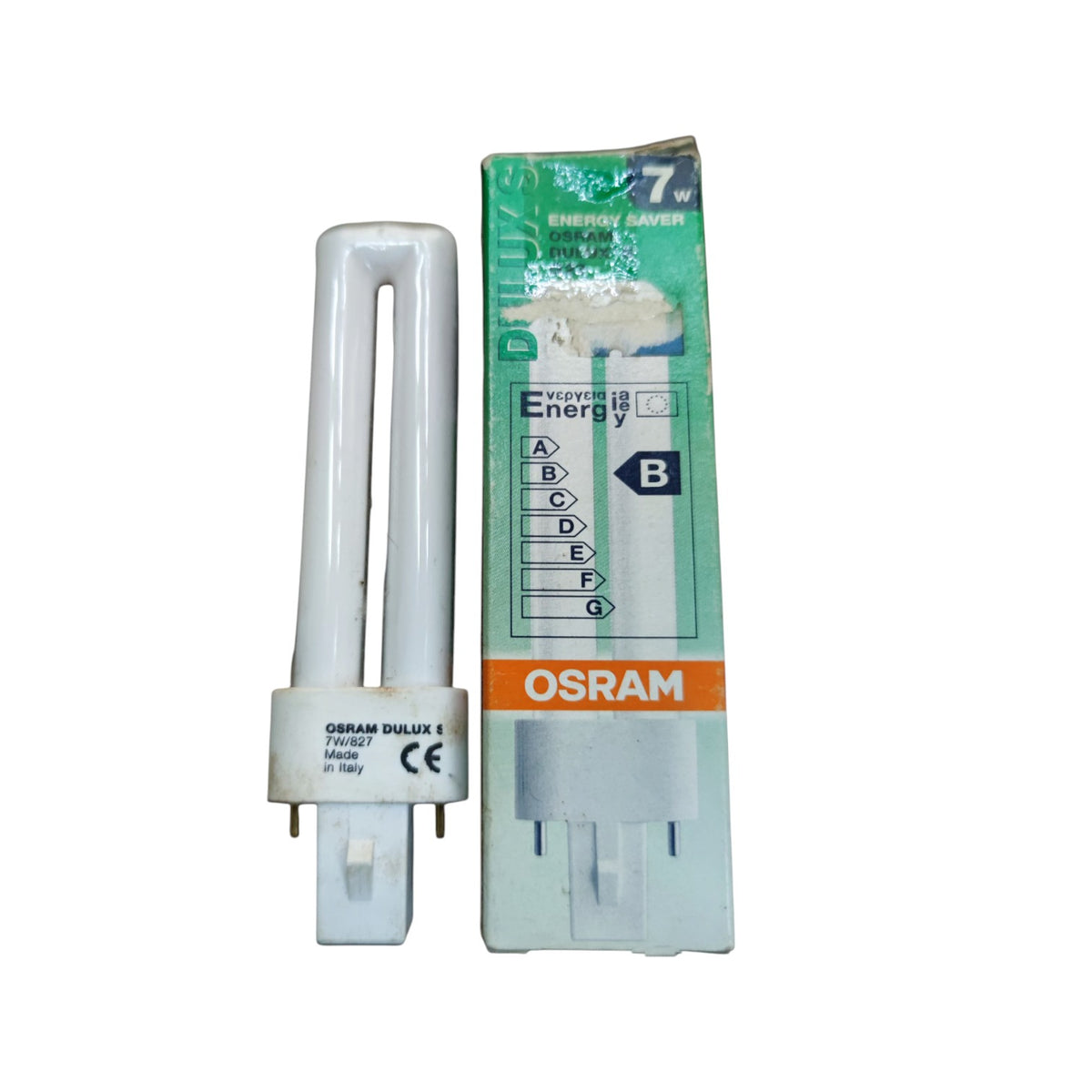 An OSRAM 7W CFL energy saver light bulb next to its original green and orange retail packaging box, shown on a plain white background.