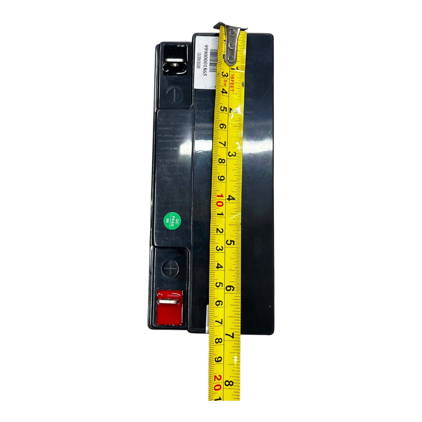 A black electrical component or terminal block shown upright on a white background, with a yellow measuring tape laid vertically alongside it to indicate size.
