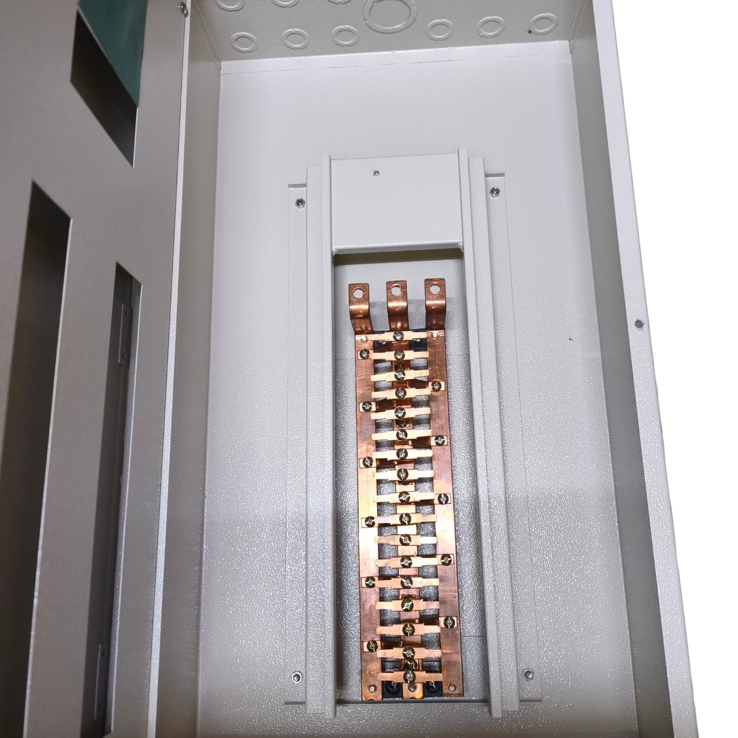 An electrical distribution panel or fuse box showing a copper bus bar with multiple terminal posts inside a gray metal enclosure.