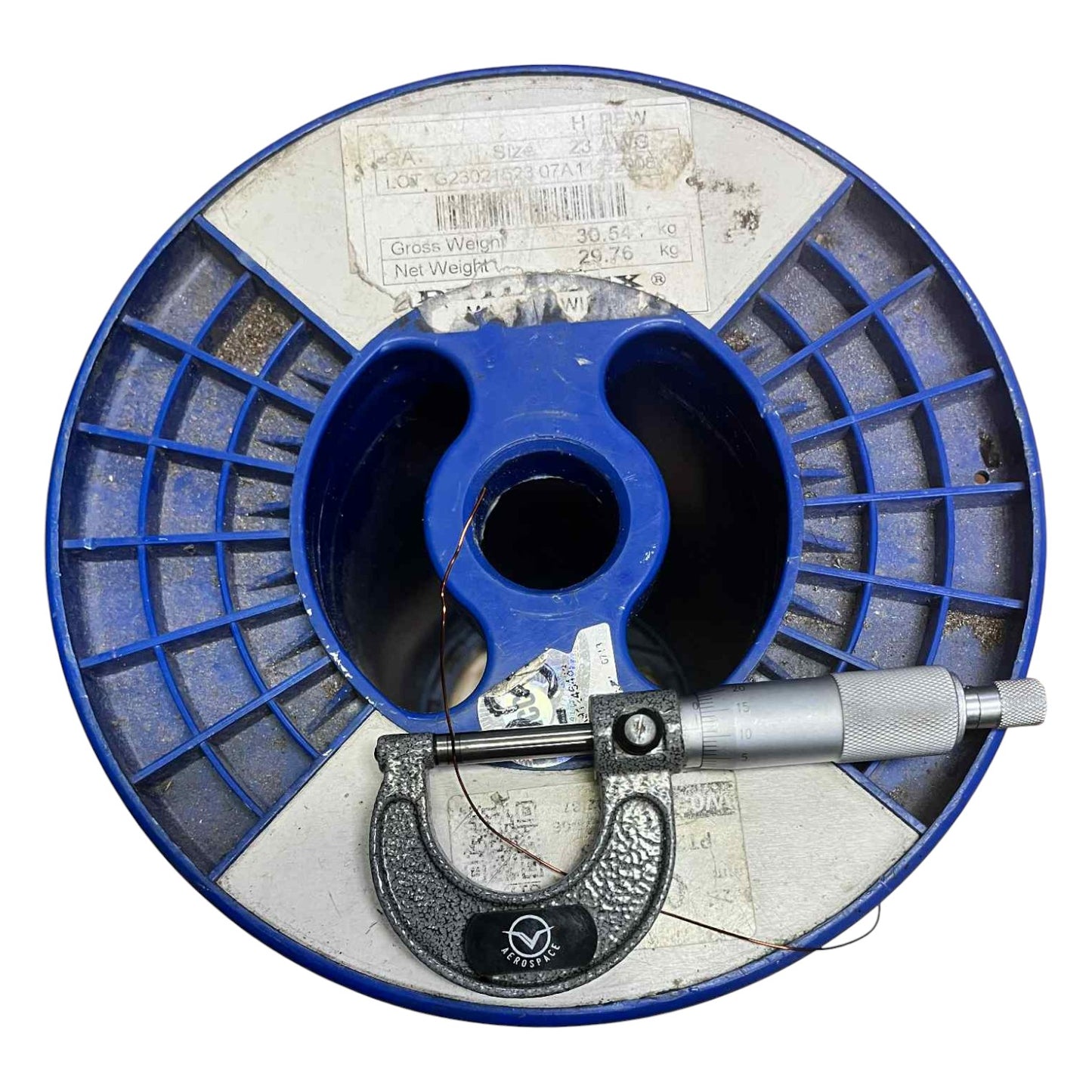 Blue spool with a micrometer on a white background