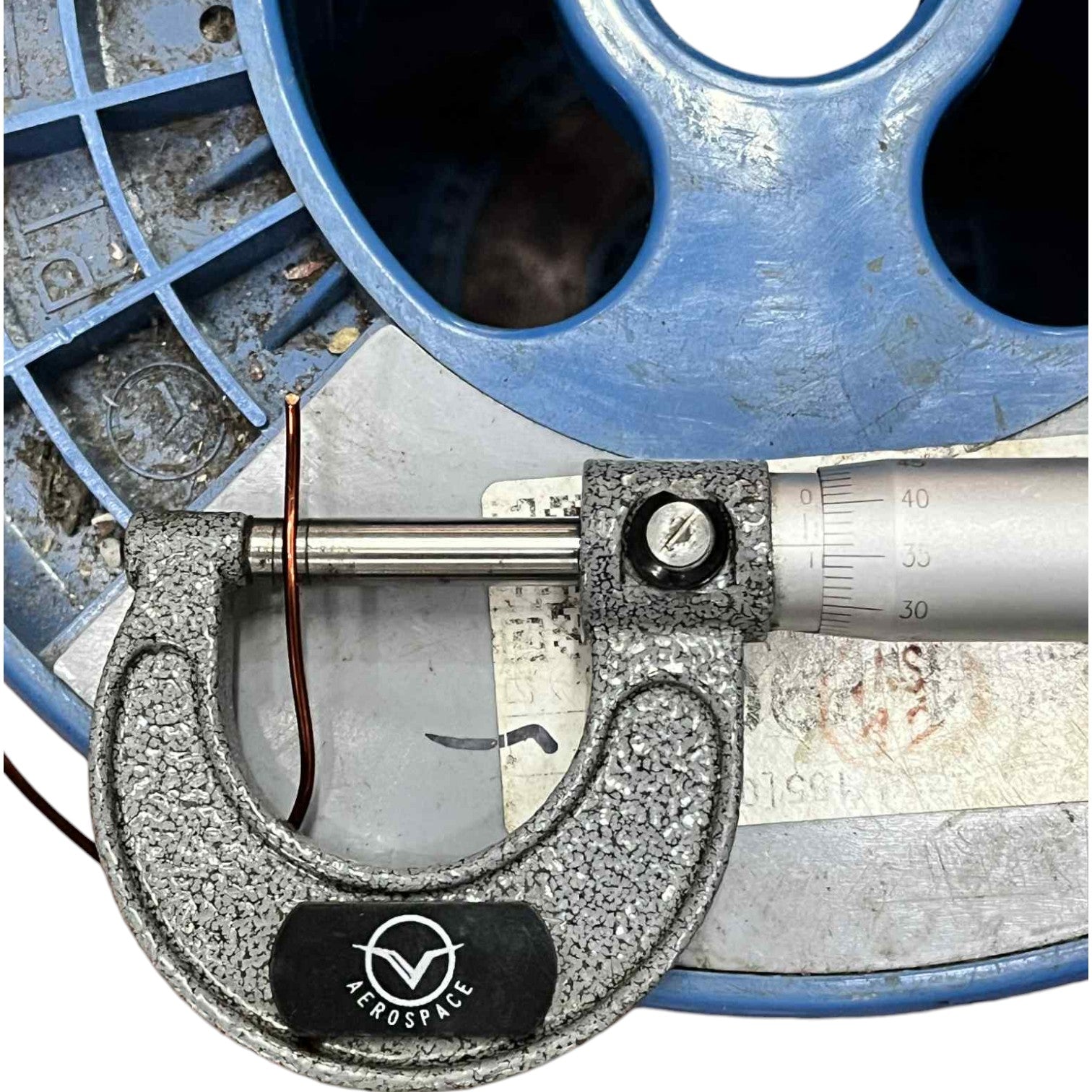 Micrometer with 'Aerospace' branding on a mechanical background