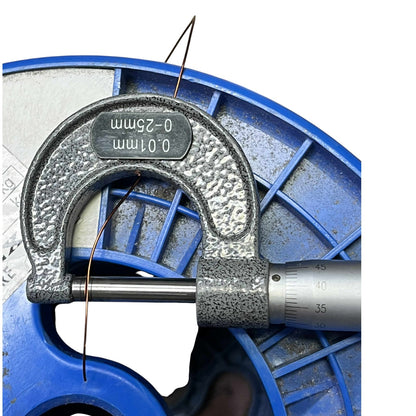 Close-up of a micrometer measuring a thin wire on a white background