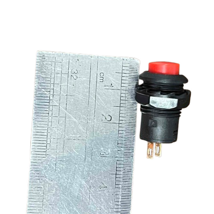 Red Push Lock 1A 220V switch next to a ruler for size reference