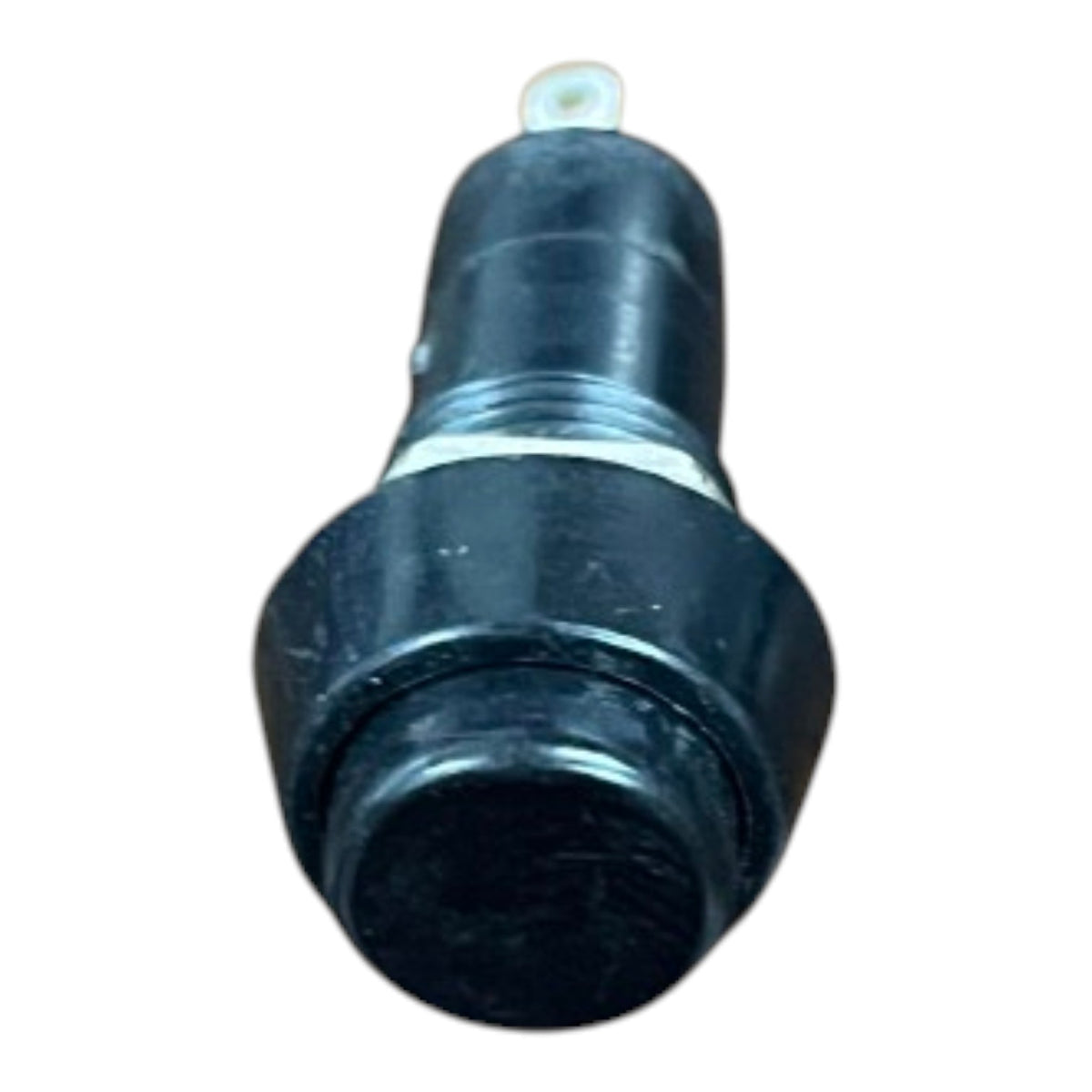 A black plastic automotive-style button or switch with a small white tab on top, isolated on a white background.