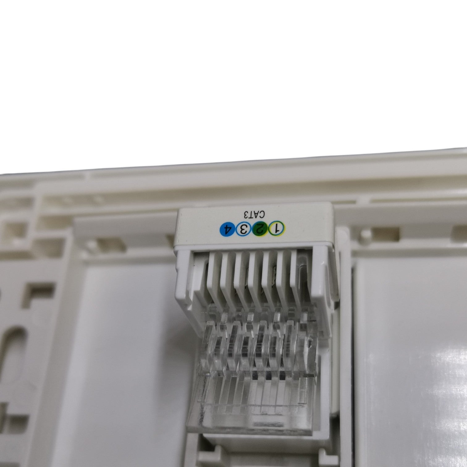 Close-up of a white CAT6 RJ45 network module connector with colored pin labels (blue, green, orange) on a white plastic housing.