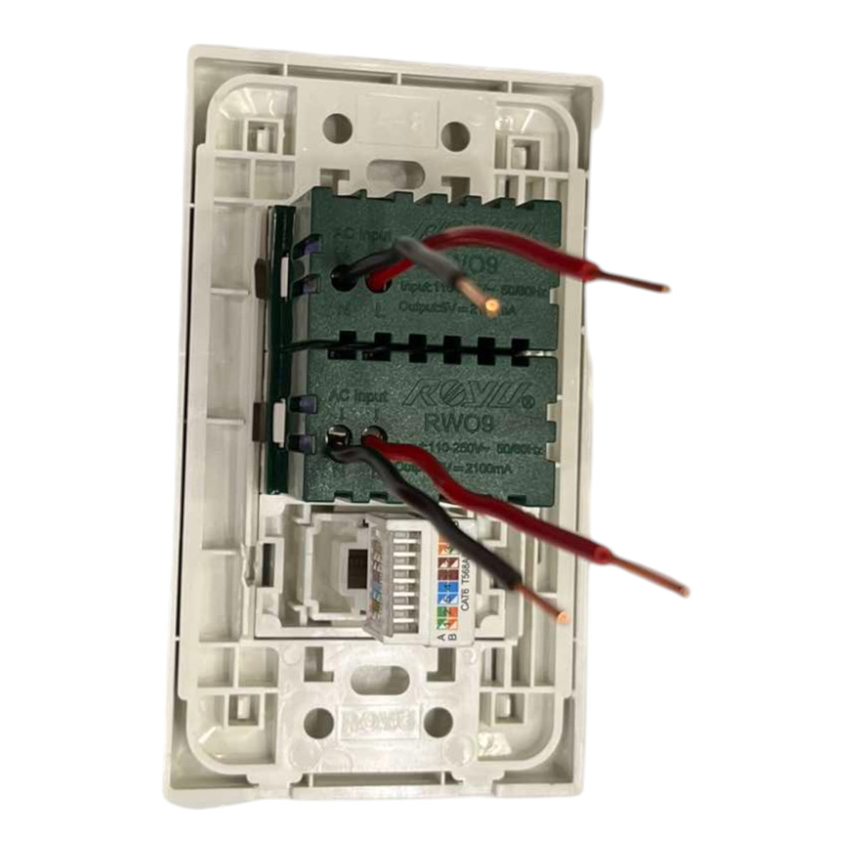 An open white plastic modular electrical junction box containing a green circuit board with red and black wires connected to it, photographed on a white background.