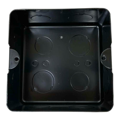 A black plastic electrical junction box with four circular screw terminals on the bottom plate, photographed from directly above on a white background.