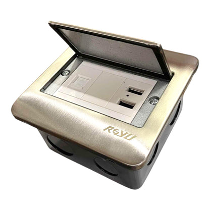A recessed electrical outlet cover with an open lid, showing built-in USB-C and USB-A ports. The outer casing has a brushed metallic gold finish with the brand name 'ROKU' debossed on the front, and the interior base is black.