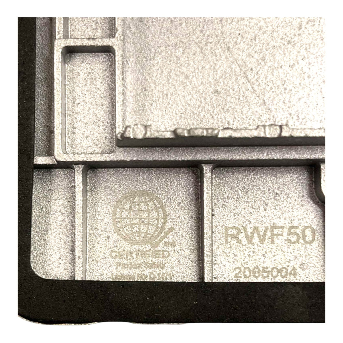 Close-up of a gray cast-metal component with molded cavities, featuring embossed text including 'RWF50', 'CERTIFIED', and 'Made in USA'.