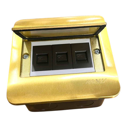 A three-button electrical switch panel with a brushed gold metal faceplate, a hinged transparent lid, and three black rocker switches on a white backing, shown against a plain white background.