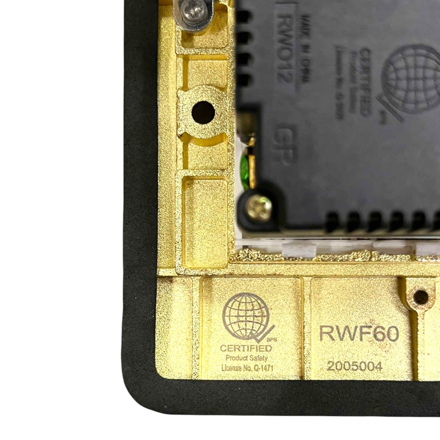Close-up of the inner frame of a black and gold electronic device, showing a gold metal chassis, a black circuit board module, and certification markings including 'RWF60' and 'CERTIFIED'.