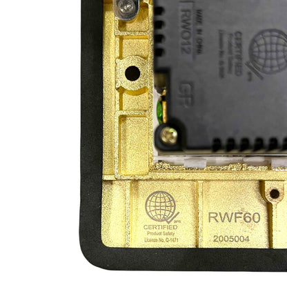 Close-up of the inner frame of a black and gold electronic device, showing a gold metal chassis, a black circuit board module, and certification markings including 'RWF60' and 'CERTIFIED'.