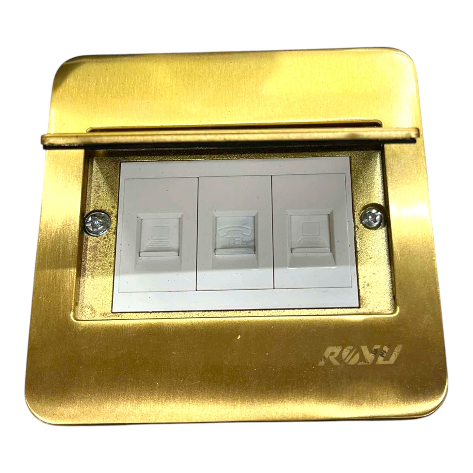 A brass three-gang light switch plate cover with white switch modules inside, featuring a hinged top cover and a debossed 'RAV' brand logo on the bottom right.