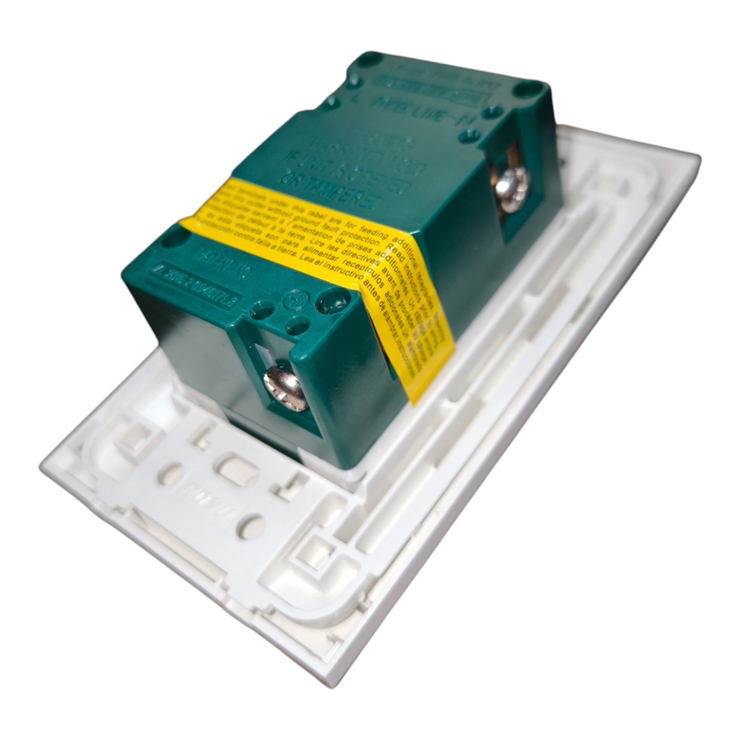 A green electrical surge protector with a yellow warning label, mounted on a white plastic wall switch plate against a white background.