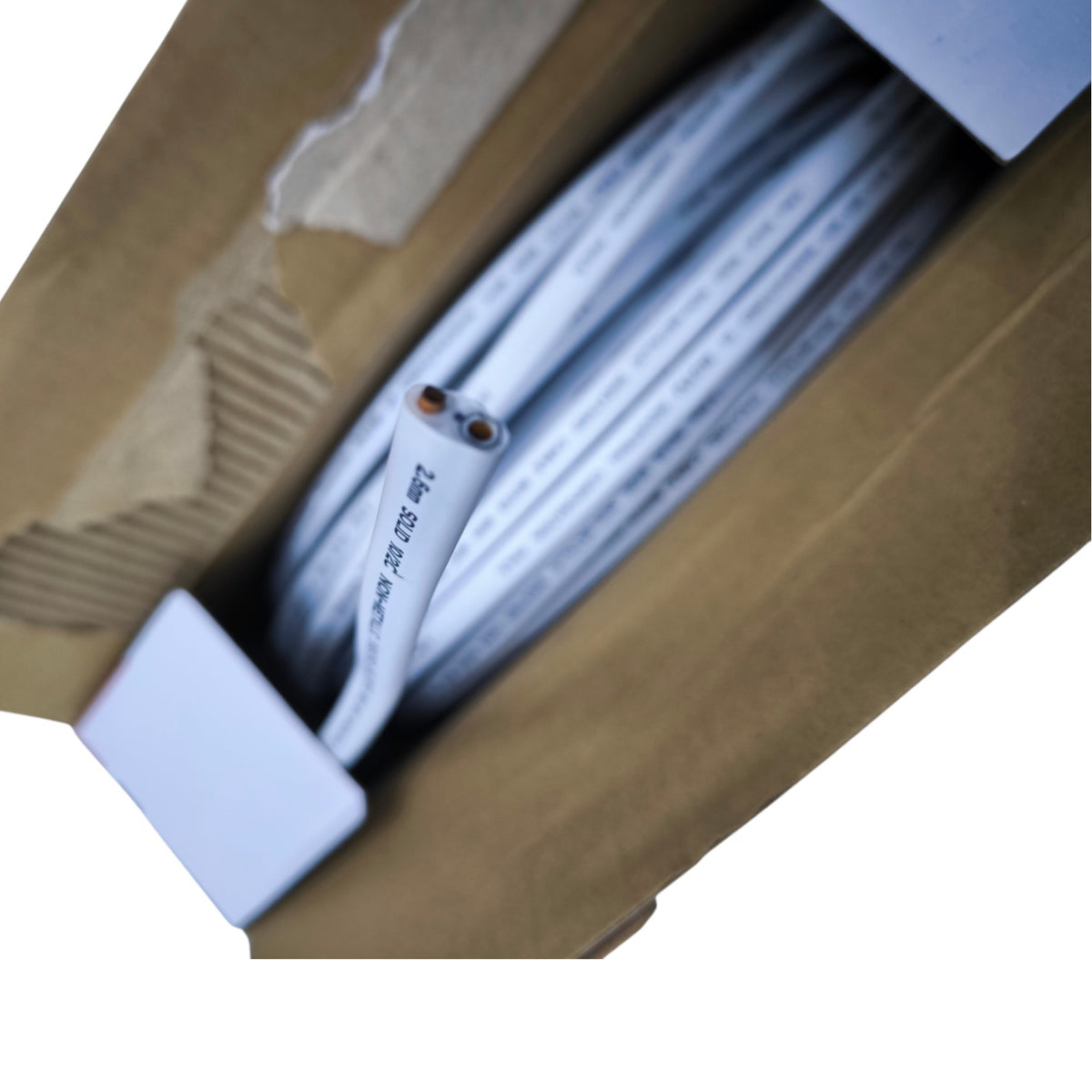A coiled white cable with printed specifications, partially inside a brown cardboard box with white protective inserts.