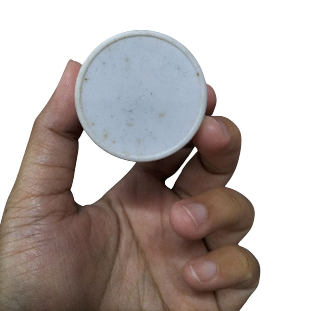 Hand holding a SYSCAP 100MFD 250V AC Motor Running capacitor showing the circular design