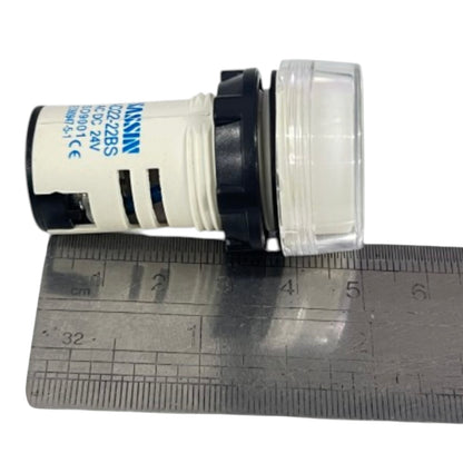 A small cylindrical electrical component with a white body, black end caps, and a clear plastic cover, shown next to a metal ruler for scale on a white background. The white body has blue printed text including the brand name 'Murr Elektronik'.