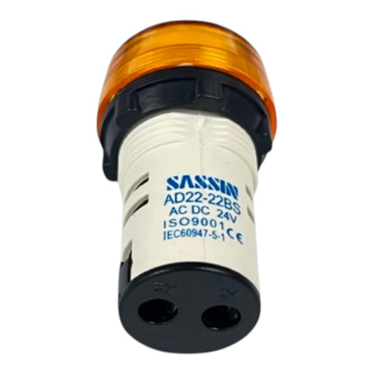 A SASSIO industrial indicator light with an amber orange top, a white body, and a black base with two terminal holes, shown on a plain white background.