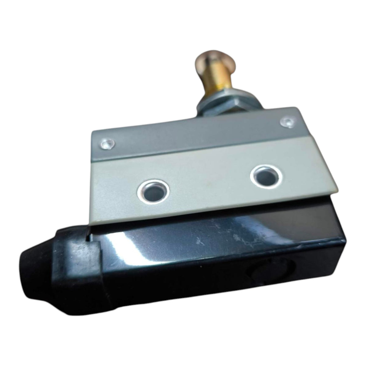 A small industrial mechanical component with a black body, silver metal plate, and a brass-toned cylindrical pin at the top, shown on a plain white background.