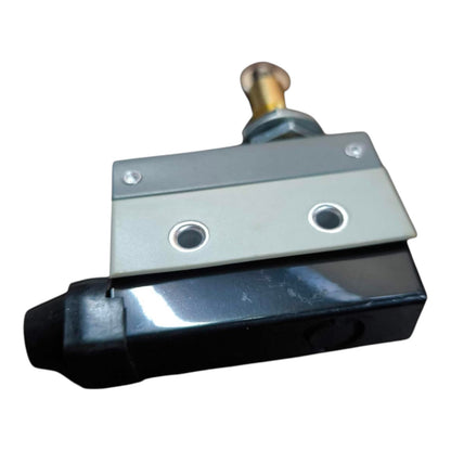 A small industrial mechanical component with a black body, silver metal plate, and a brass-toned cylindrical pin at the top, shown on a plain white background.