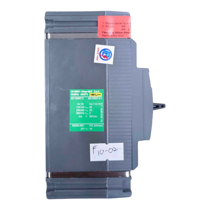 A Siemens industrial electrical module, model 6ES7 2-EX2 430-4600-01, in gray plastic with a green and white technical label, a red warning sticker, and a white handwritten label.