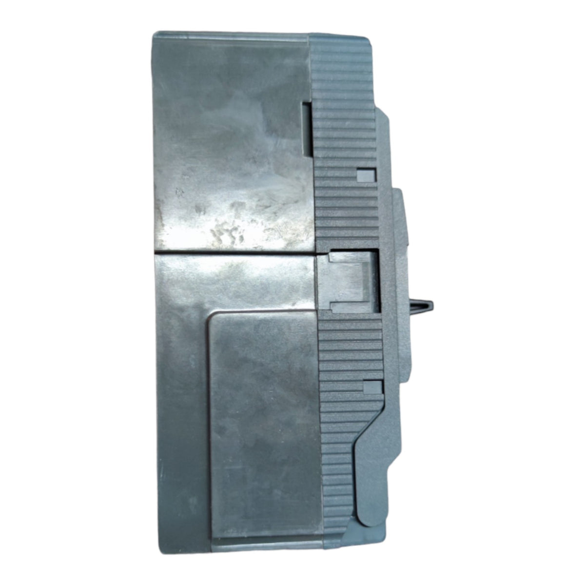 A gray plastic or metal mechanical component with a ribbed side and a small protruding pin, shown against a plain white background.